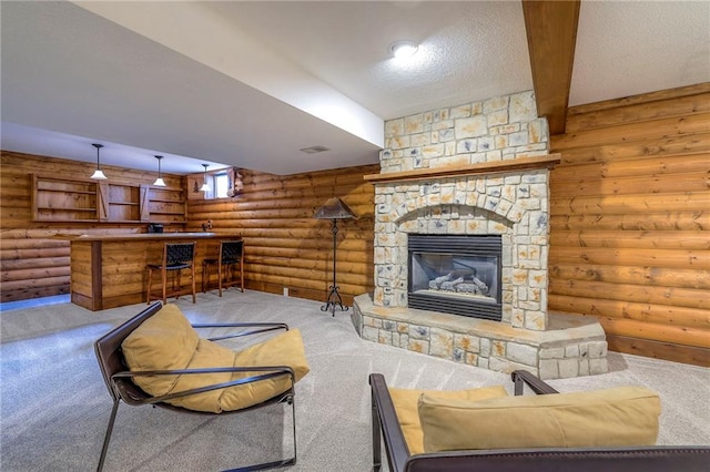 carpeted living room featuring a fireplace, log walls, a dry bar, a textured ceiling, and beamed ceiling