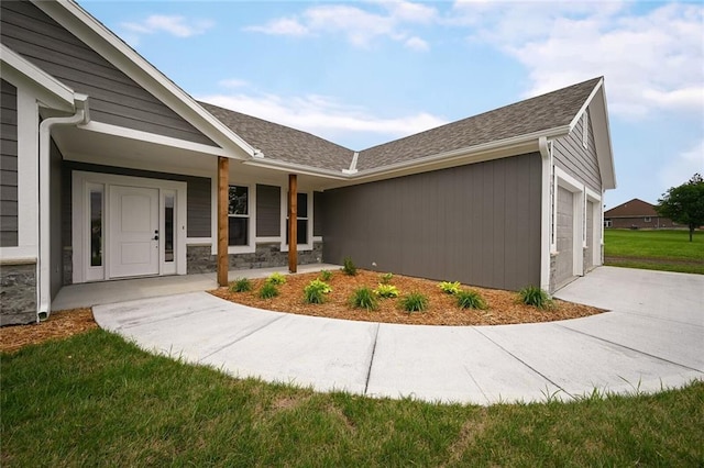 property entrance featuring a garage and a lawn