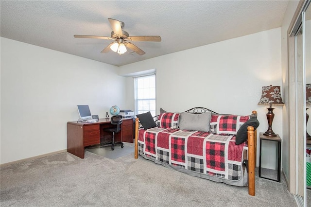 carpeted bedroom with a textured ceiling and ceiling fan