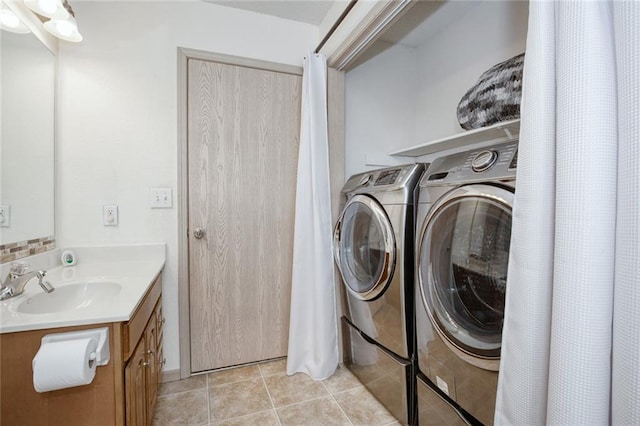 clothes washing area featuring light tile patterned floors, sink, and separate washer and dryer