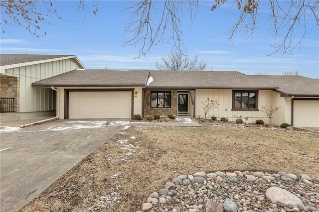 view of front of house with concrete driveway, a garage, stone siding, and roof with shingles