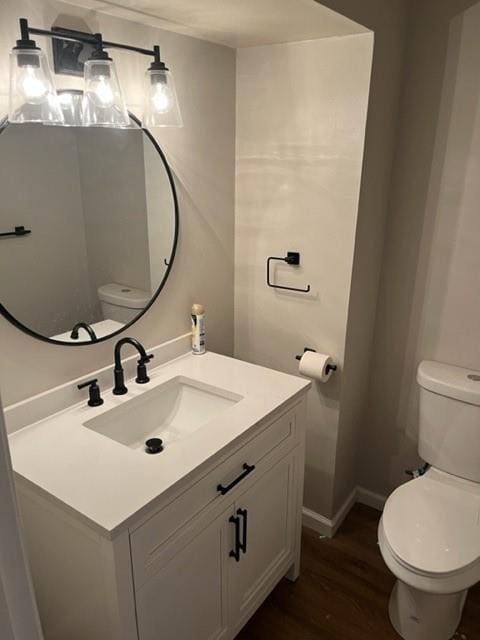 bathroom featuring vanity, wood-type flooring, and toilet