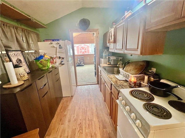 kitchen with white appliances, lofted ceiling, sink, and light hardwood / wood-style flooring