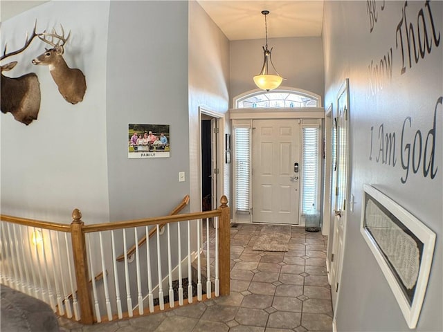 foyer featuring heating unit and a towering ceiling