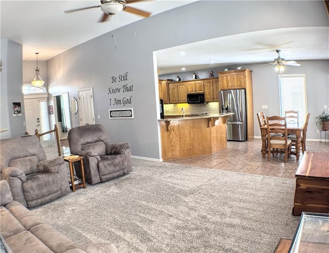 living room with vaulted ceiling, light carpet, and ceiling fan