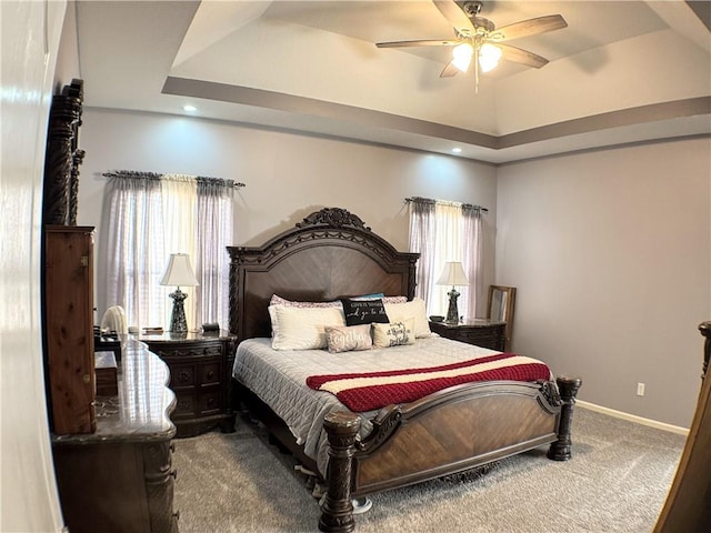 bedroom featuring carpet flooring, ceiling fan, and a tray ceiling