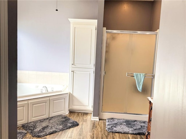 bathroom featuring hardwood / wood-style flooring and separate shower and tub