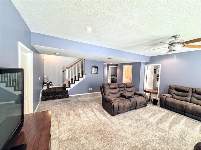 carpeted living room featuring a textured ceiling and ceiling fan