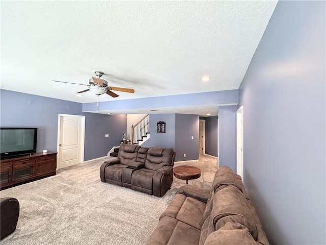 living room featuring ceiling fan, a textured ceiling, and carpet flooring