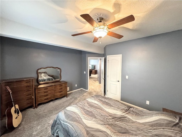 bedroom featuring ceiling fan, light carpet, and a textured ceiling