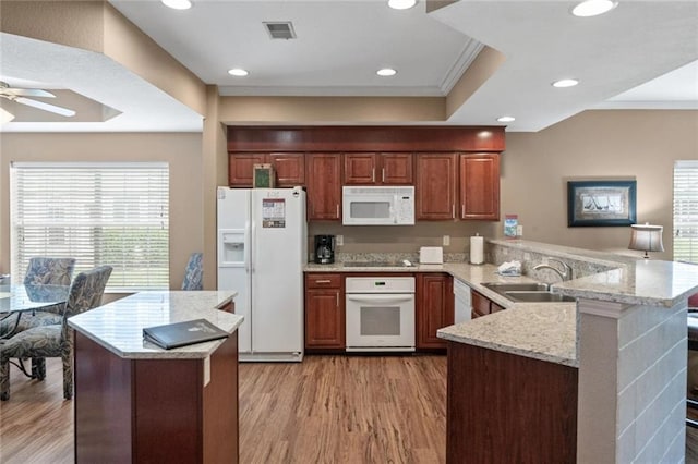 kitchen featuring sink, white appliances, light wood-type flooring, kitchen peninsula, and ceiling fan