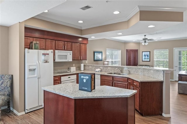 kitchen with white appliances, a center island, light stone countertops, kitchen peninsula, and light wood-type flooring