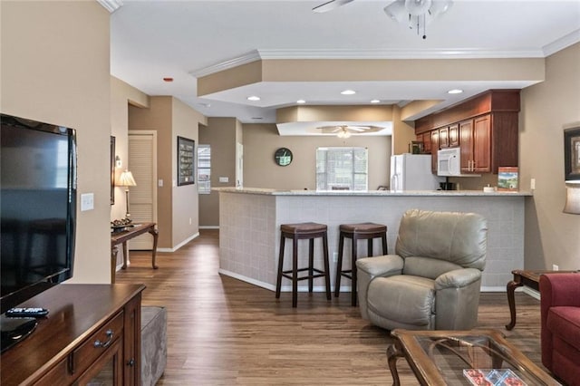 living room with ornamental molding, hardwood / wood-style floors, and ceiling fan