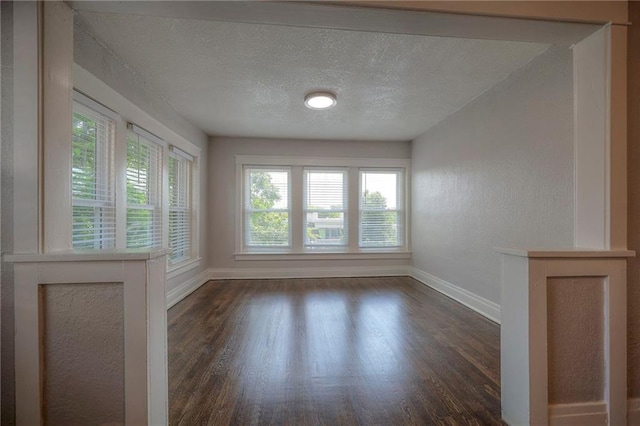 unfurnished room with dark hardwood / wood-style floors and a textured ceiling