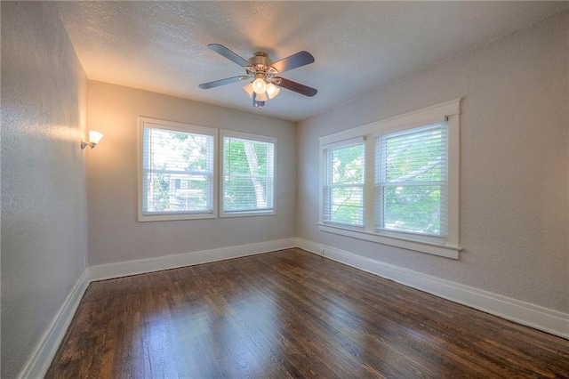 empty room with dark hardwood / wood-style flooring, ceiling fan, and a textured ceiling