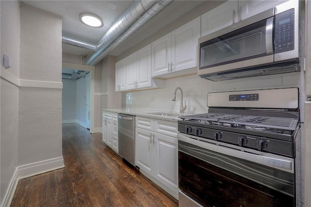 kitchen featuring sink, white cabinetry, dark hardwood / wood-style floors, stainless steel appliances, and decorative backsplash