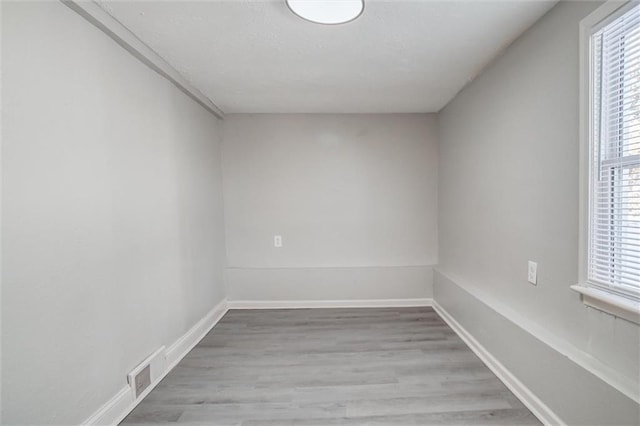 empty room with a healthy amount of sunlight and light hardwood / wood-style floors