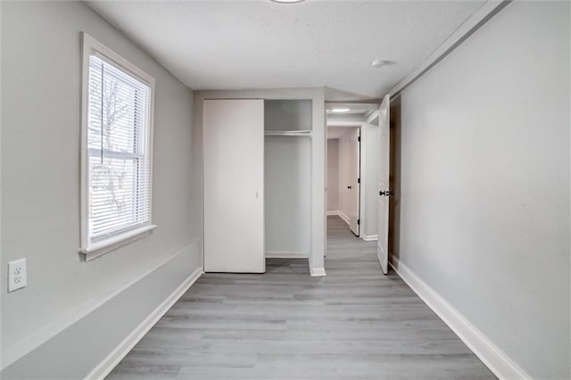 unfurnished bedroom with light hardwood / wood-style floors and a closet