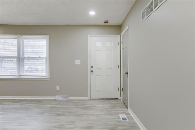 foyer featuring a textured ceiling and light hardwood / wood-style floors