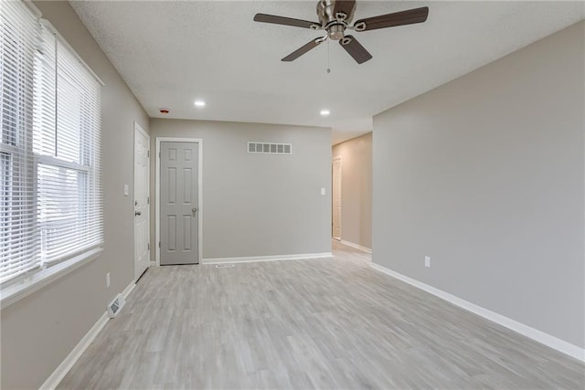 empty room featuring ceiling fan, a textured ceiling, and light hardwood / wood-style floors