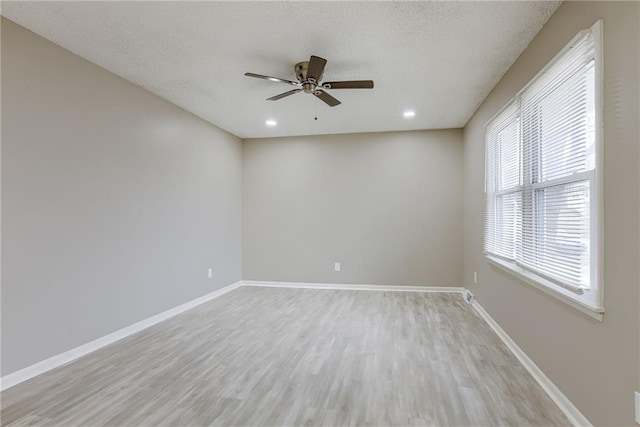 unfurnished room featuring a textured ceiling, ceiling fan, and light wood-type flooring