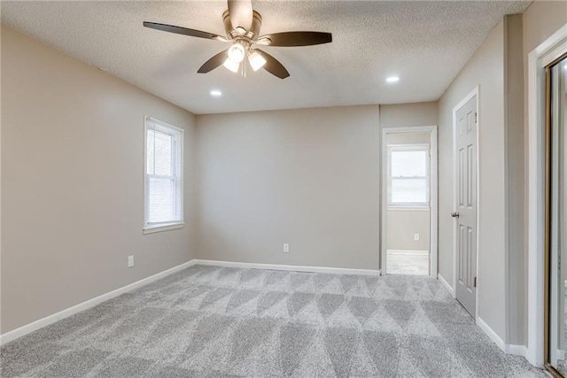 carpeted spare room with ceiling fan and a textured ceiling