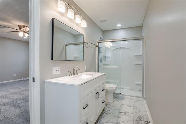 bathroom with a shower with door, vanity, ceiling fan, and toilet