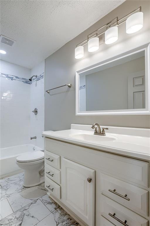 full bathroom featuring vanity, toilet, tiled shower / bath combo, and a textured ceiling