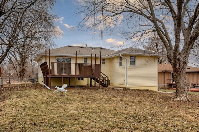 rear view of property with a deck and a lawn