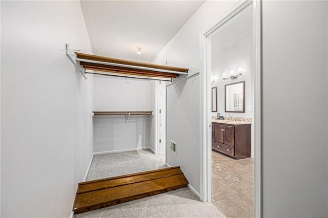 walk in closet featuring a sink, visible vents, and light colored carpet