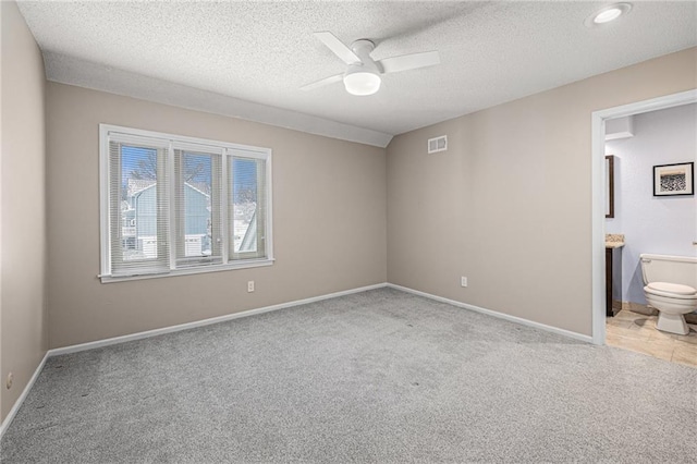 unfurnished bedroom with light colored carpet, visible vents, a ceiling fan, a textured ceiling, and baseboards