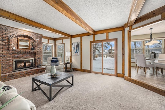 living area with a fireplace, carpet flooring, a textured ceiling, beamed ceiling, and baseboards