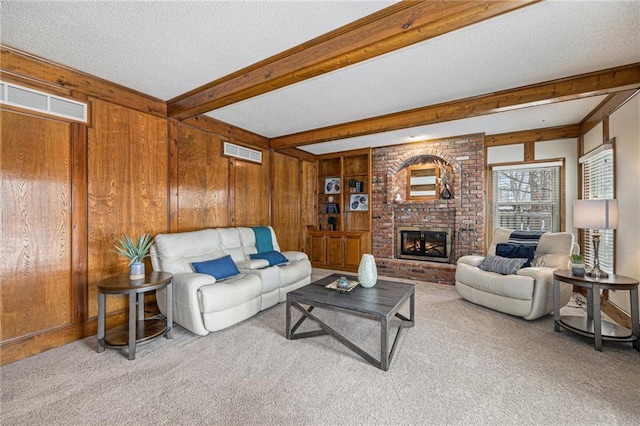 living room with wood walls, visible vents, beamed ceiling, and light colored carpet