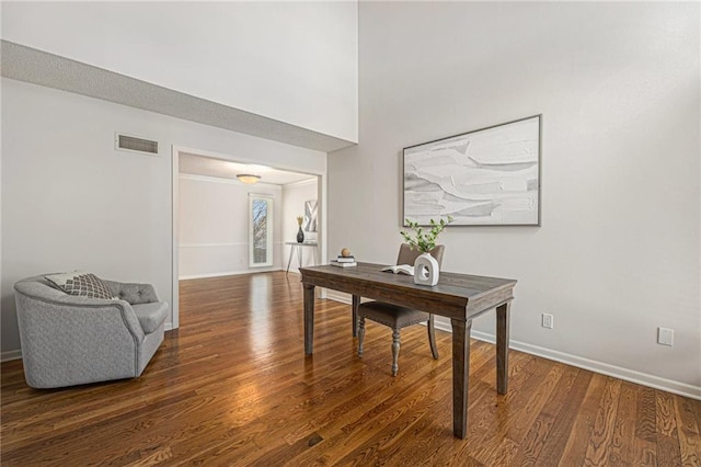 office space with dark wood-style floors, visible vents, and baseboards