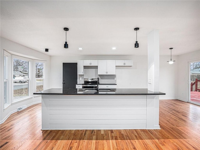 kitchen with pendant lighting, sink, electric range, light hardwood / wood-style floors, and white cabinets