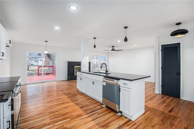 kitchen with hanging light fixtures, sink, white cabinets, and appliances with stainless steel finishes