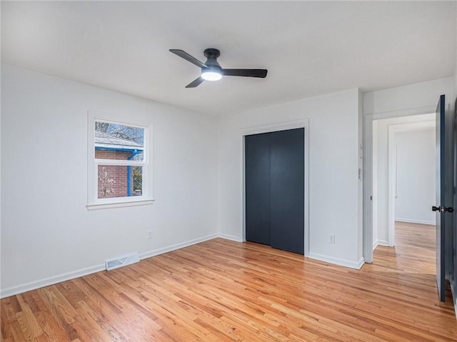 unfurnished bedroom featuring ceiling fan, light wood-type flooring, and a closet