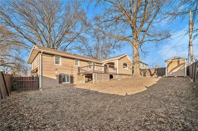 rear view of property featuring a deck and a storage unit