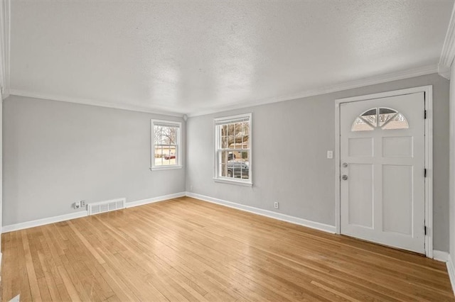 entrance foyer featuring crown molding, light hardwood / wood-style floors, and a textured ceiling