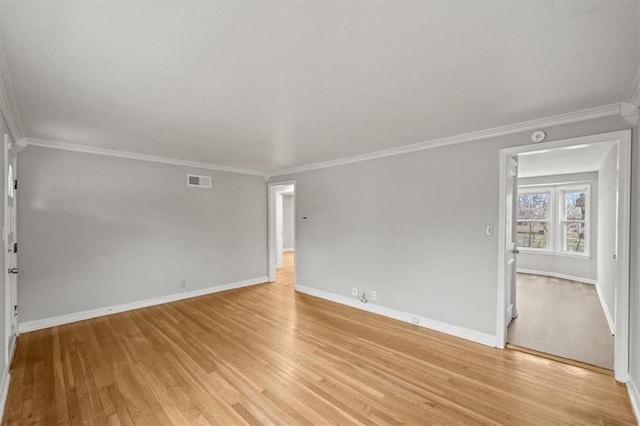 empty room featuring crown molding and light hardwood / wood-style flooring