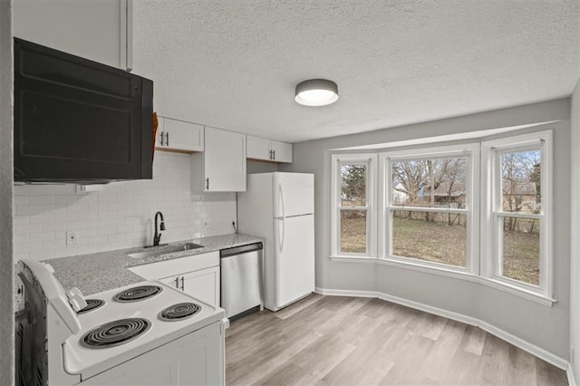 kitchen with sink, white appliances, light hardwood / wood-style flooring, and white cabinets