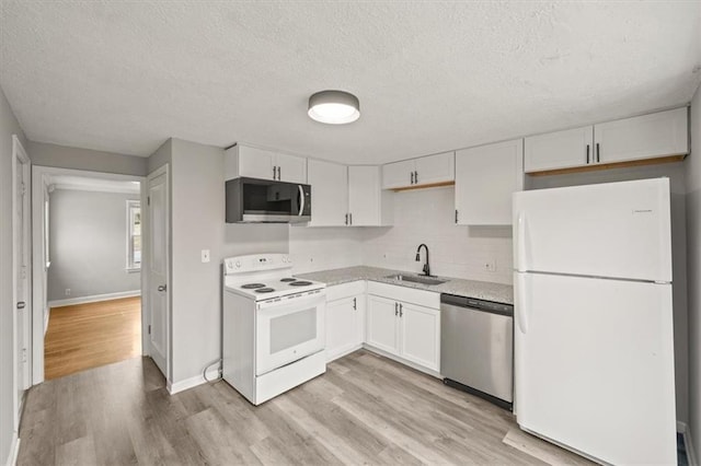 kitchen with sink, stainless steel appliances, light hardwood / wood-style floors, white cabinets, and decorative backsplash