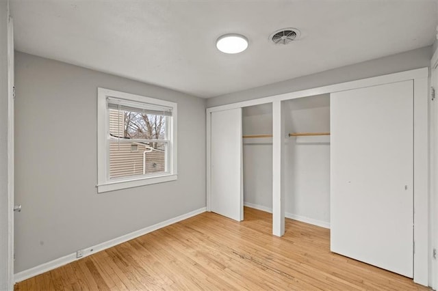 unfurnished bedroom with light hardwood / wood-style floors and multiple closets