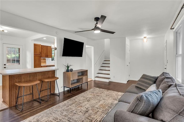 living room featuring dark wood-type flooring and ceiling fan