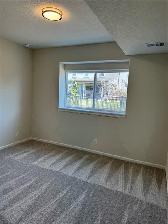 25297 W 149th Ter, Olathe, KS 66061 - carpeted empty room featuring a textured ceiling and baseboards