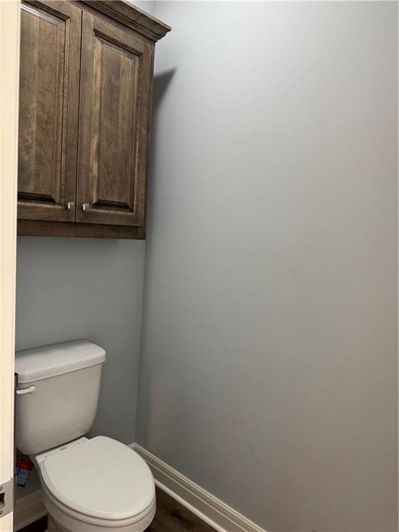 25297 W 149th Ter, Olathe, KS 66061 - bathroom with baseboards, toilet, and wood finished floors
