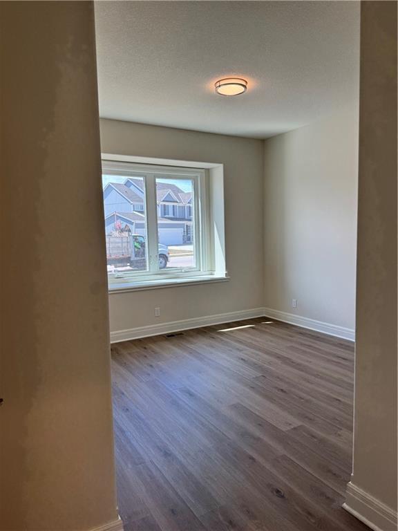 25297 W 149th Ter, Olathe, KS 66061 - spare room with dark wood-type flooring and baseboards