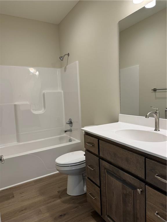 25297 W 149th Ter, Olathe, KS 66061 - full bathroom featuring toilet, vanity, wood finished floors, and shower / bathtub combination