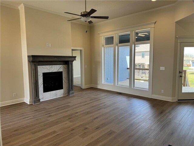 25297 W 149th Ter, Olathe, KS 66061 - unfurnished living room featuring a ceiling fan, dark wood finished floors, a premium fireplace, ornamental molding, and baseboards