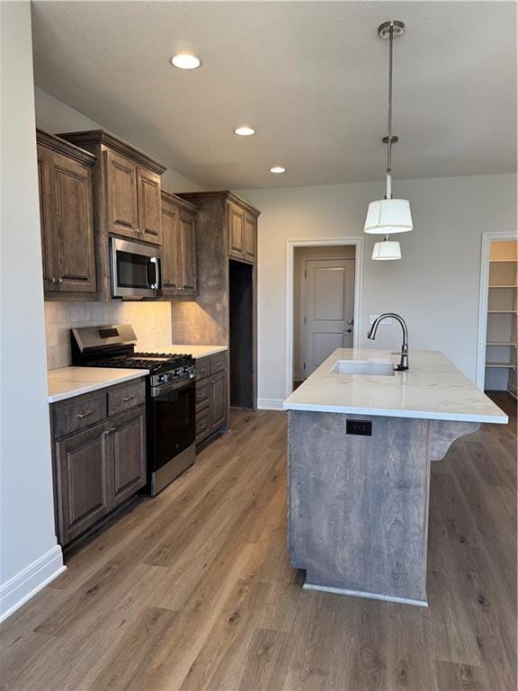 25297 W 149th Ter, Olathe, KS 66061 - kitchen featuring stainless steel appliances, a sink, baseboards, wood finished floors, and recessed lighting